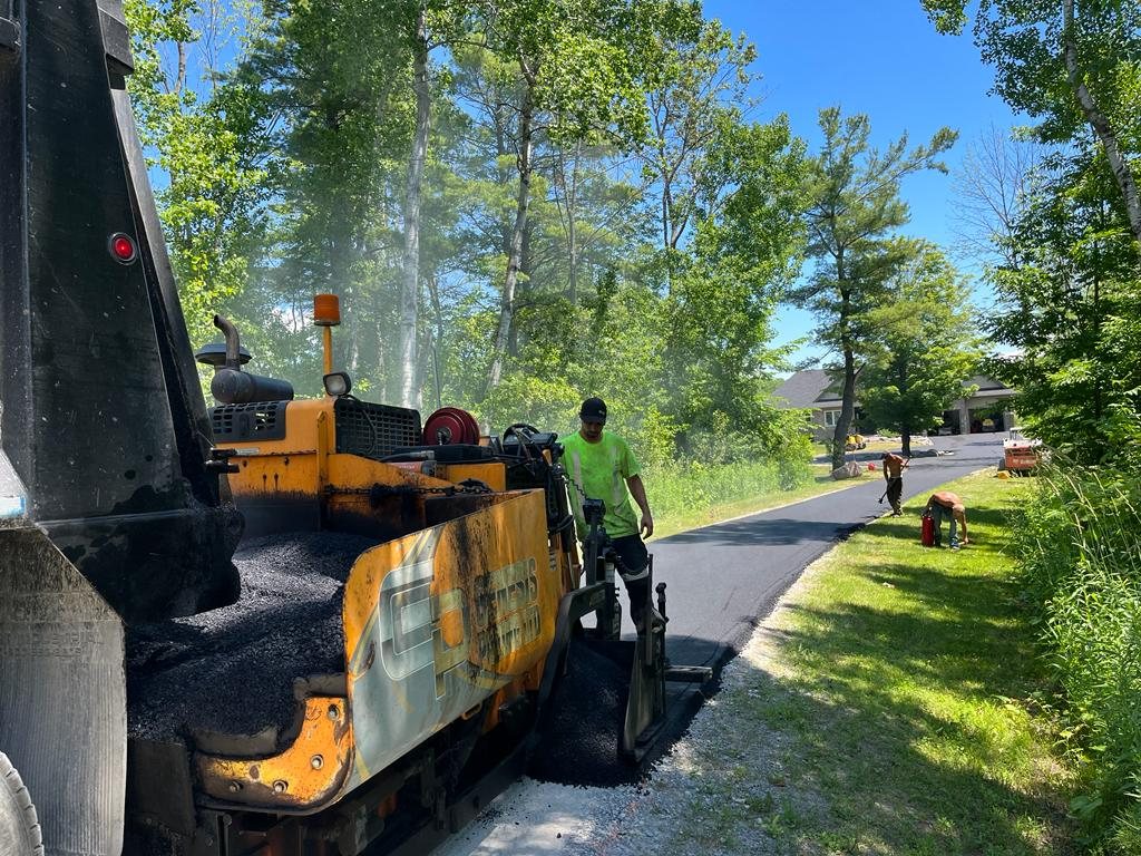 Genesis paving equipment and team working on a residential driveway