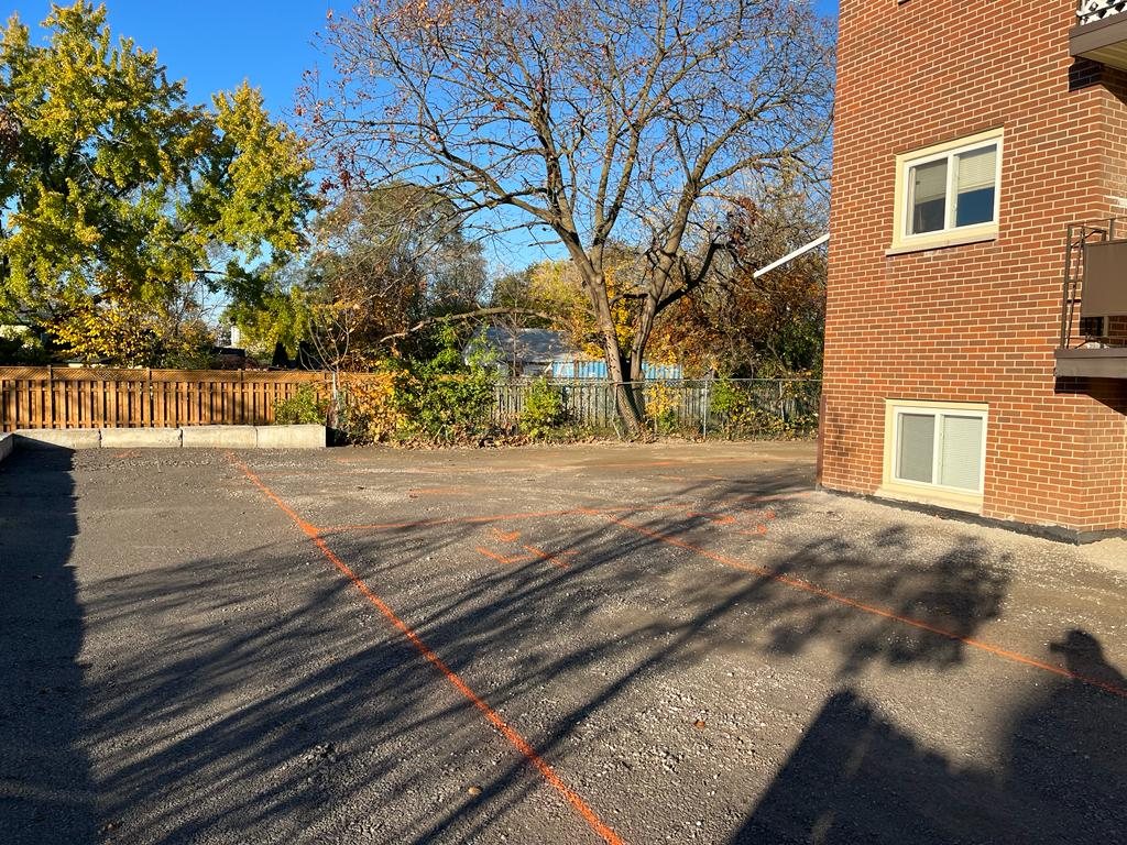 apartment building's parking lot being prepared for paving