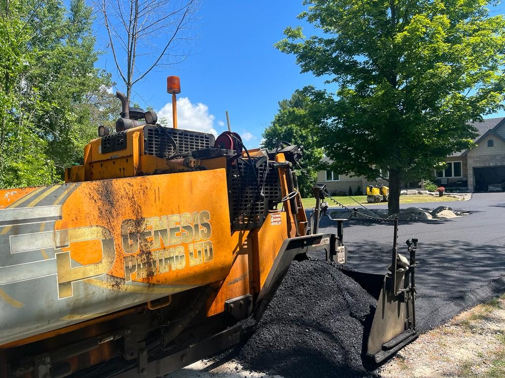 Genesis paving equipment working on a residential driveway