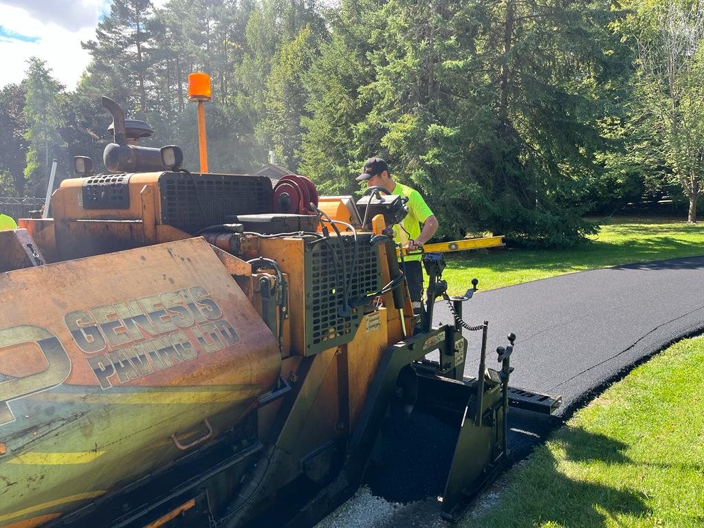 Genesis paving equipment working on a residential driveway