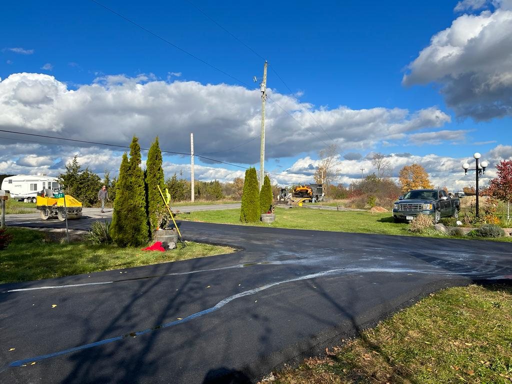 Genesis team working on paving a commercial road and driveway