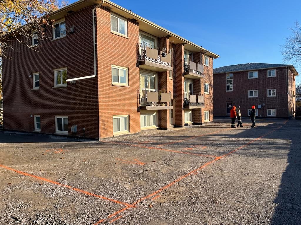 Genesis team preparing an apartment building's parking lot for paving