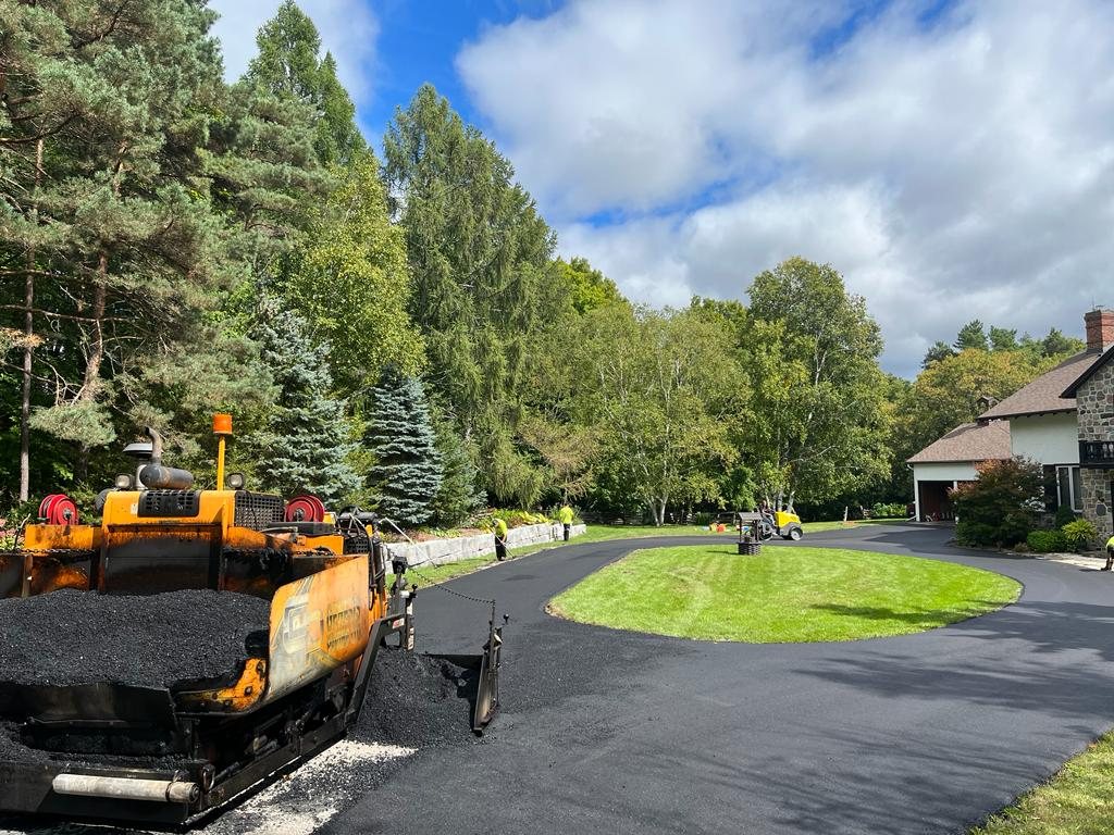 Genesis paving equipment and team working on a residential driveway